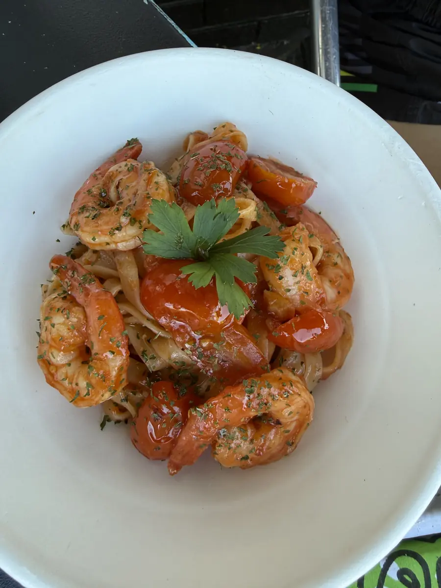 Prawn fettuccine in a tomato sauce, topped with parsley